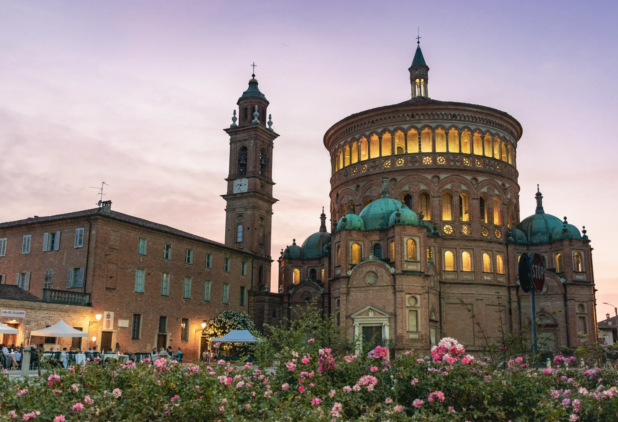 Um grupo de visitantes sentados no gramado em frente à Basílica de Santa Maria della Croce